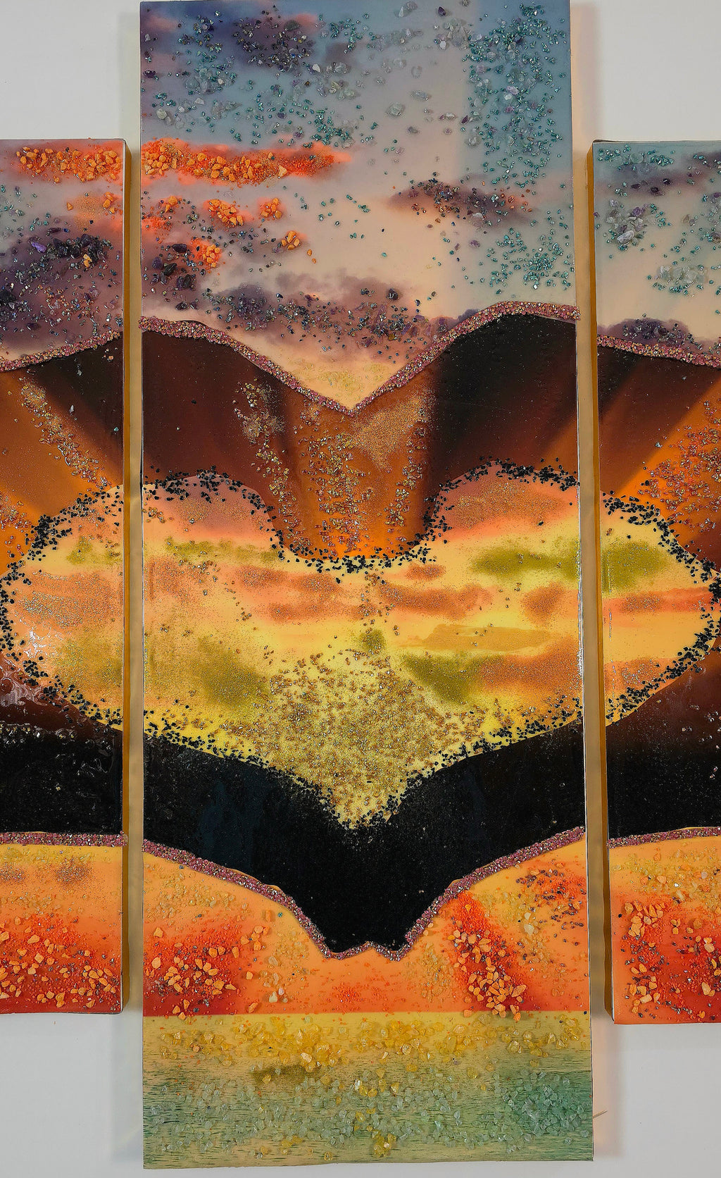 Close-up of the tall centre panel 3 of Sunset in Our Hands, with parts of panels 2 and 4 visible on either side, highlighting the central glowing landscape and handcrafted details.